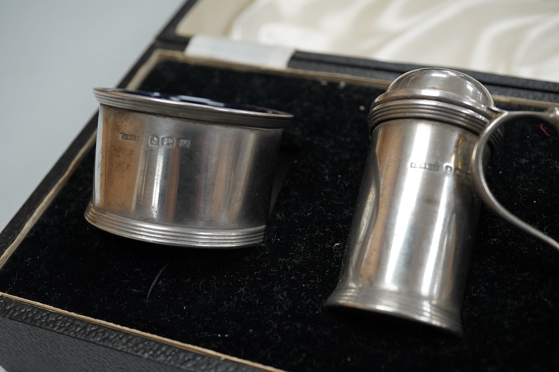 A George V silver tall cream jug, Birmingham, 1930, 17.2cm, a 1950's silver small mug, London, 1955 and a cased 1930's silver three piece condiment set.